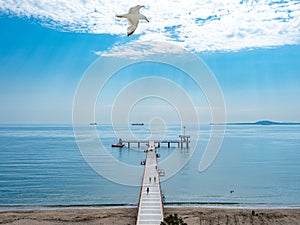 A large bridge with a pier and jumping and walking people in Burgas, Bulgaria