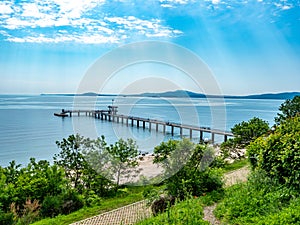 A large bridge with a pier and jumping and walking people in Burgas, Bulgaria