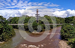 Large bridge spanning a Tena river in the woods, Ecuador