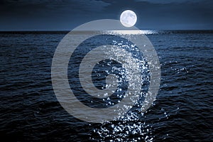 Large Bright FUll Moon Rises Over A Calm Ocean Scene photo