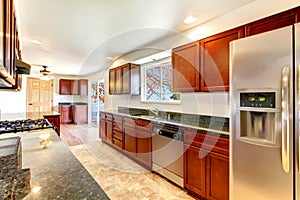 Large bright kitchen with dark cherry cabinets.