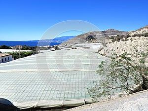 Large bright plastic agricultural greenhouses on hillside Southern Spain photo