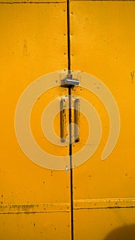 Large brightly painted yellow door on a lock-up in an industrial property