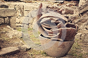 Large broken clay pots stand on the ground .toned