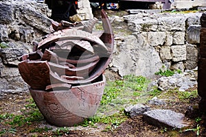 Large broken clay pots stand on the ground .toned