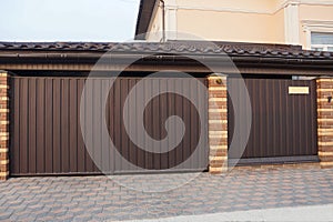 A large brown gate and a metal door and part of the fence