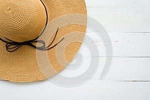 Large brown lady hat on white wooden background with copy space, travel beach holiday ideas concept