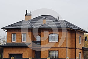 Large brown private brick house with tiled roof