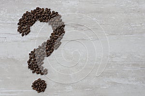 A large  brown question mark made of natural grain flavored coffee lies on the table