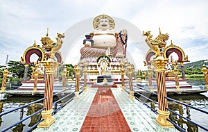 A large Buddha image sits in the middle of the water at Wat Plai Laem on Koh Samui, Sarat Thani Province, Thailand photo