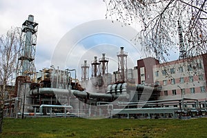 Large building with production equipment with pipes, pumps, compressors and distillation columns at a petroleum refining