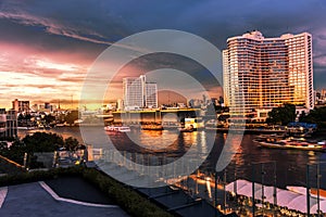 Large buildings in the city by the river at sunset