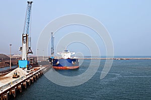 A large bulk carriers, tugboats at the port under cargo operations and underway. Close-up view of ships constructions and equipmen
