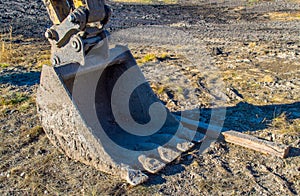 Large bulldozer bucket covered in mud at a construction site
