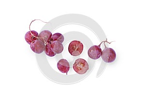 A large bunch of red grapes with green grape leaves on a white background
