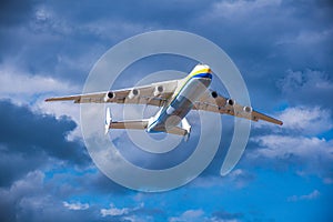 A large cargo plane flies in the blue sky. Aviation air transport. Airplane symbol.