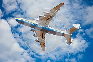 A large cargo plane flies in the blue sky. Aviation air transport. Airplane symbol.