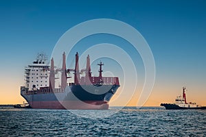 large carrier ship floating afternoon in sea, tugboat dragging container ship, blue sky evening background and sea front