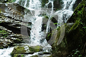 Large cascading waterfall in a mountain forest.