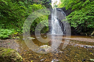 Large cascading waterfall tumbling into a peaceful pool. Falling foss waterfall, Yorkshire Dales