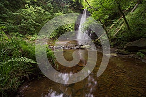 Large cascading waterfall tumbling into a peaceful pool. Falling foss waterfall, Yorkshire Dales