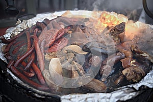 In a large cast-iron cauldron, meat, sausages are suspected at the feast. Street festivities
