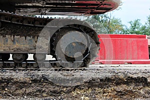 Large caterpillar of excavator on the background plastic enclosures.