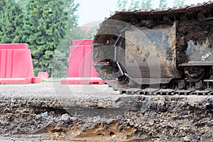 Large caterpillar of excavator on the background plastic enclosures.