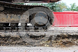 Large caterpillar of excavator on the background plastic enclosures.