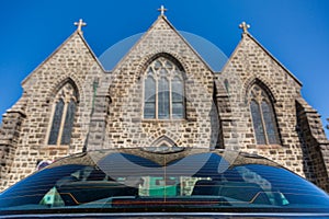 Large Catholic Church viewed from behind a car