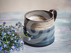 A large ceramic coffee mug with creams on a wooden tray for a peppy morning with a cool plan