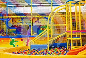 Large children`s playroom with a slide and colorful balls in entertainment center