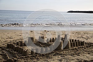 Large children's sand castle on the beach small ocean waves