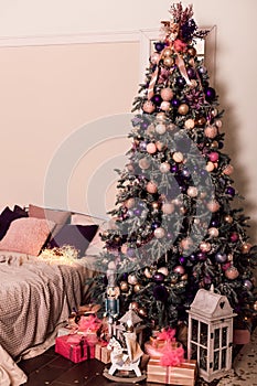 Large Christmas tree in the bedroom by the bed