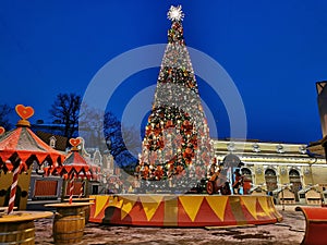 A large Christmas tree with mice in uniforms and a cannon at the bottom, the red sleigh of Santa Claus at the Christmas fair in St