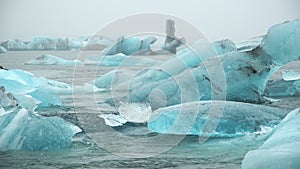 Large chunk of ice and pure blue iceberg in foggy glacier lagoon, Icelandic nature misty weather, 8k 4:2:2 10 bit