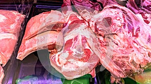 Large chunks of fresh pork  on the counter in the supermarket