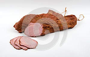 Large chunks of pork delicacy in a spice sprinkle with slices on a white background