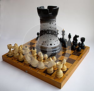 Large clay rook on a wooden chessboard with pieces. Chess game