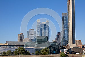 the large clock tower sits behind a massive building in a city