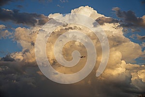 a large cloud with a plane flying through it in the sky