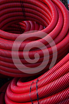 Large coils of red, plastic, water irrigation hosing