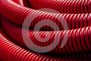 Large coils of red, plastic, water irrigation hosing