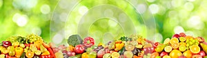 Large collection of fresh fruits, vegetables and berries on green background