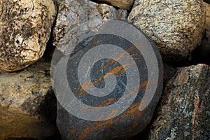 Large charcoal gray rock with cooper swirls photo