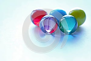5 Large coloured marbles on white surface top right - stock photo photo