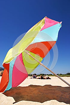 Large colourful umbrella on a sunny beach in Spain