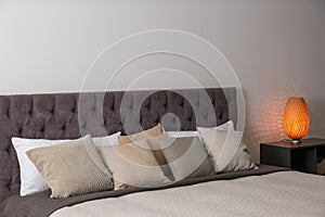 Large comfortable bed near light wall in modern room