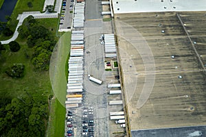 Large commercial distribution storehouse with many semitrucks unloading and uploading retail products for international