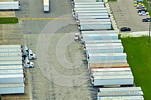 Large commercial distribution storehouse with many semitrucks unloading and uploading retail products for international